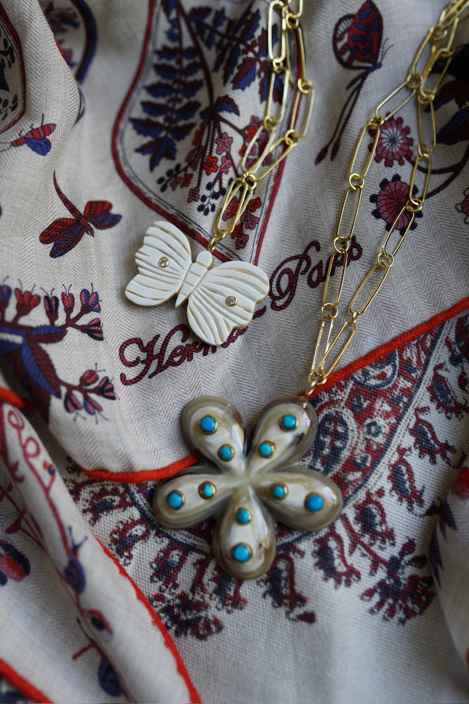 Butterfly-shaped necklace with blue stones on a patterned fabric background