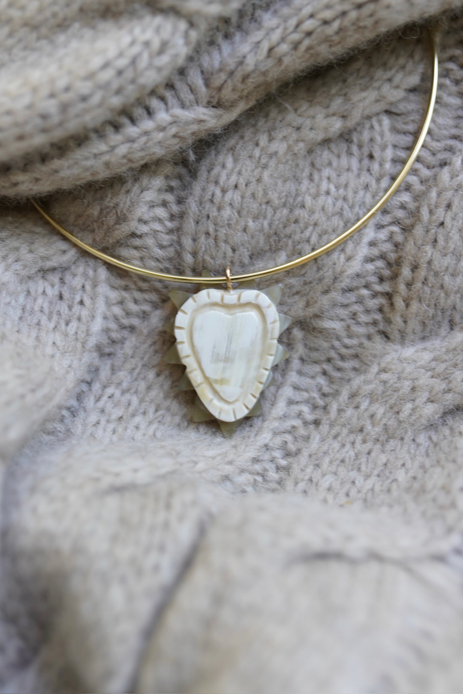 Necklace with a heart-shaped pendant on a textured fabric background