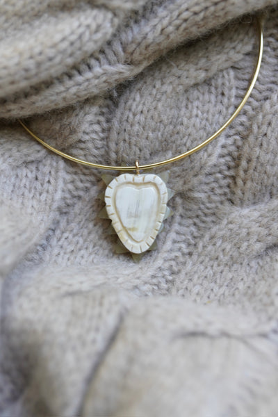 Necklace with a heart-shaped pendant on a textured fabric background