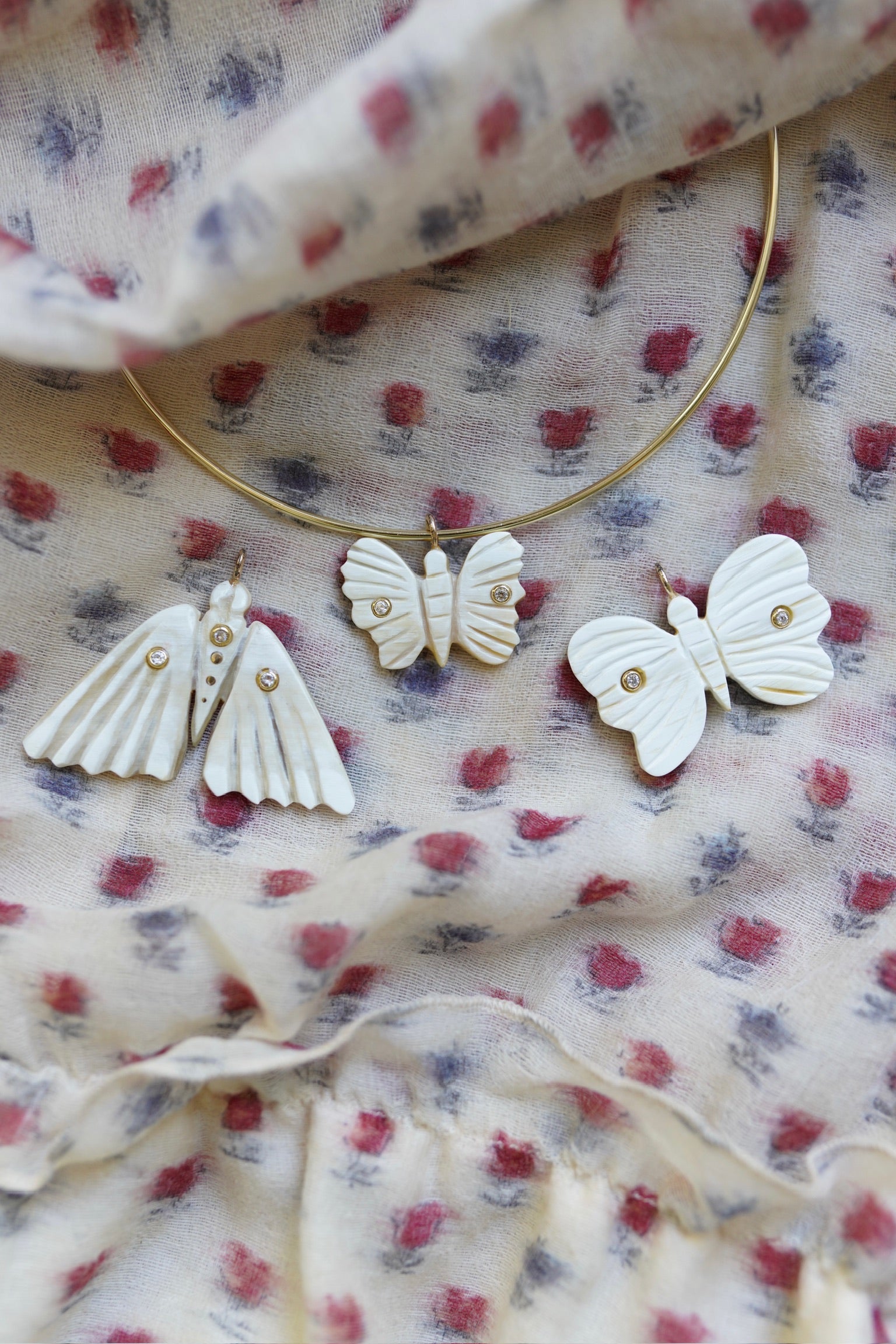 Dragonfly and Butterfly-shaped earrings on a floral fabric background
