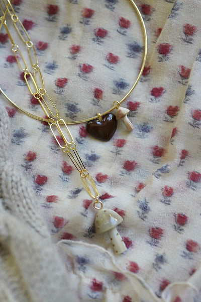 Gold necklace with heart-shaped pendant on floral fabric