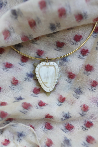 Necklace with a heart-shaped pendant on a floral fabric background
