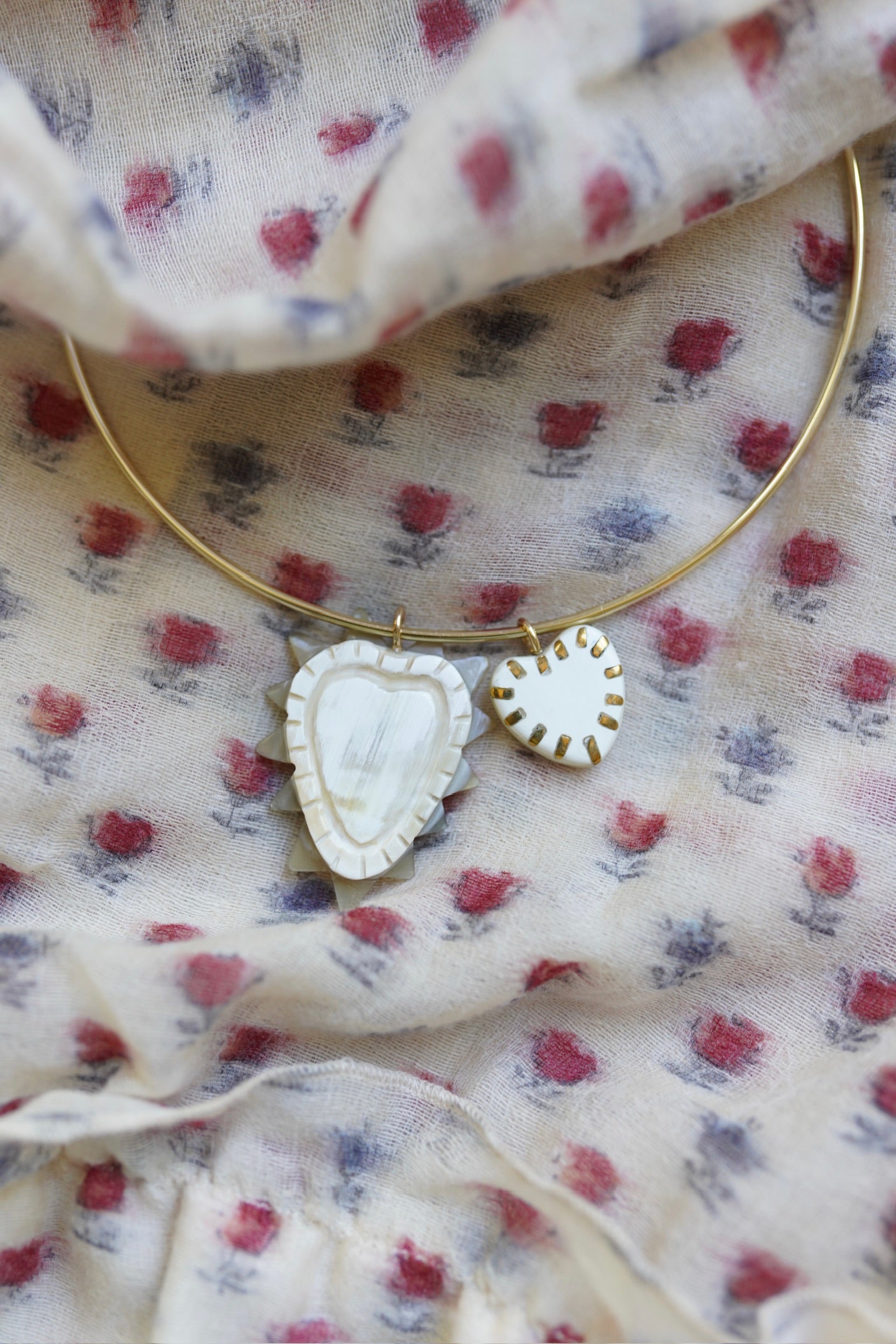 Necklace with heart-shaped pendants on a floral fabric background