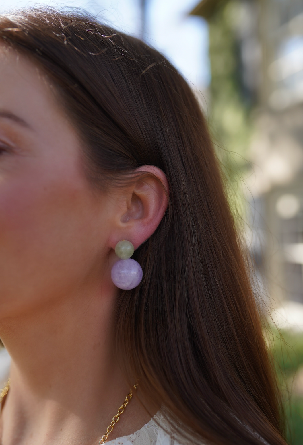 Antigua Gemstone Bubble Earrings in green and lavender purple on a model outside